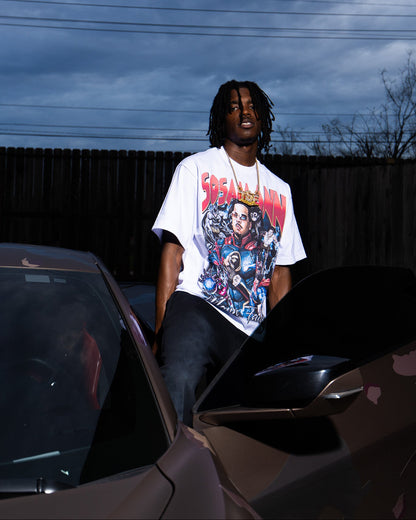 Person wearing a superhero graphic t-shirt sitting on a corvette with a dark sky background