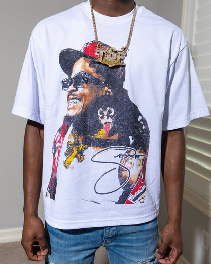 Person wearing a Tsf chain and a white t-shirt with a graphic design of a Sosamann in a hat and sunglasses.